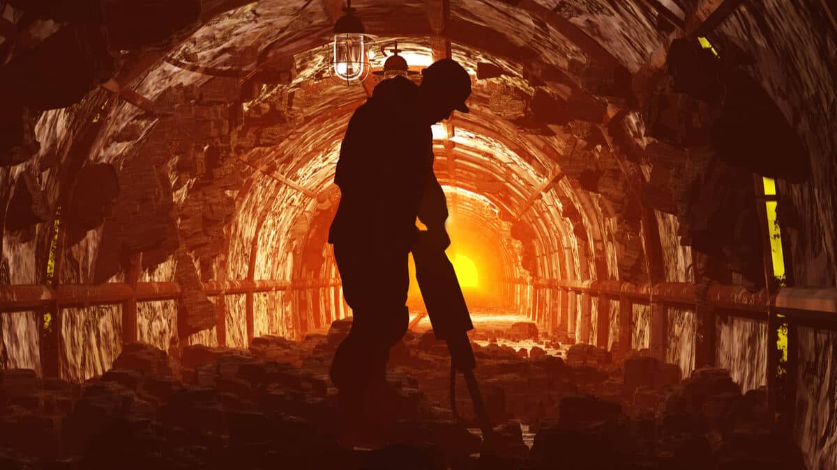 Un mineur sachant miner manie sa pioche à la mine